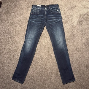 Replay anbass hyperflex - Snygga blå jeans från Replay i modellen Anbass. De har en slim passform och är tillverkade i deras bekväma Hyperflex-material. Klassisk femficksdesign med dragkedja och knapp. Perfekta för en stilren look. Storlek 30/32. Grymt snygg tvätt! Inga tecken på användning. 