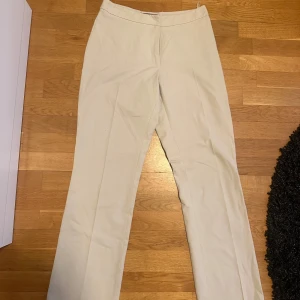 Beige byxor från L.O.G.G. - Snygga beige byxor från L.O.G.G. med en klassisk design. Byxorna har en rak passform och är perfekta för en stilren look. Tillverkade i ett bekvämt material som passar bra till olika tillfällen.