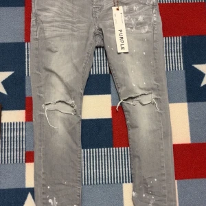 Purple brand jeans - Snygga grå jeans från Purple brand med slitningar och färgstänkseffekter. De har en modern slim passform. Jeansen har klassisk femficksdesign och knappar i midjan. Dem är storlek 31-32 och om du har frågor angående jeansen skicka bara ett meddelande✅