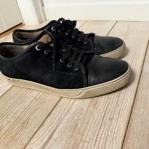 Lanvins - Snygga svarta sneakers med snörning och vit sula. Skorna har en stilren design med rund tå och är perfekta för en avslappnad look. De är tillverkade i skinn och har en klassisk siluett som passar till det mesta.