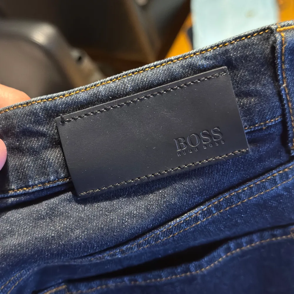 Snygga mörkblå jeans från Hugo Boss med klassisk femficksdesign. De har en rak passform och är tillverkade i ett slitstarkt denimtyg. Perfekta för en stilren look.. Farkut & Housut.