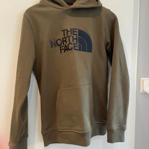 Olivgrön hoodie från The North Face - Säljer en olivgrön hoodie från The North Face. Superbra skick, inga fläckar eller andra skador. Storlek junior xl, passar herr xs.