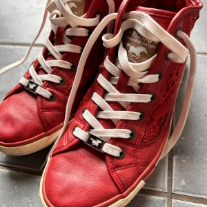 Snygga sneakers från Mustang! - Röda ankelhöga sneakers med snygga detaljer i storlek 41 från Mustang. Har några år på nacken men förutom lite avskavning på flikarna bak (bild 4) är dom i mycket bra skick.