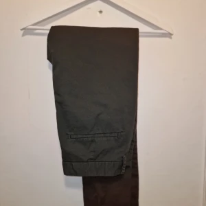 Svarta chinos - Snygga svarta chinos med en klassisk design. De har en knapp och dragkedja framtill samt fickor både fram och bak. Perfekta för en stilren look.