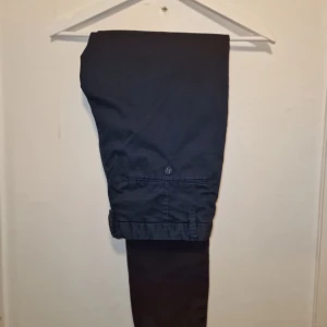 Marinblåa chinos från Whyred  - Snygga chinos som har en klassisk passform och är tillverkade i ett bekvämt material. Perfekta för en stilren look.