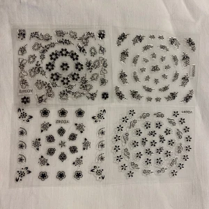 Svartvita nageldekorationer med blommor och fjärilar - Set med nageldekorationer i svart och vitt. Innehåller olika mönster som blommor, fjärilar, hjärtan och stjärnor. Perfekt för att skapa unika nageldesigner. 45kr/4st/bild, samma frakt 