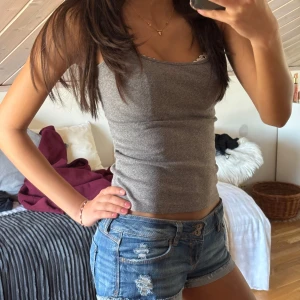 Grå ribbad linnetopp - Snygg grå ribbad linnetopp med en tight passform. Perfekt för varma sommardagar eller som ett basplagg i garderoben. Enkel och stilren design som passar till det mesta.