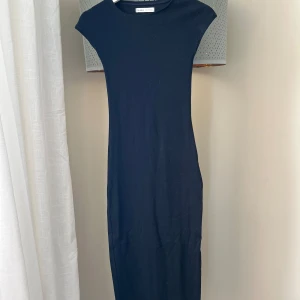 Svart klänning från Pull & Bear - Snygg svart långklänning från Pull & Bear. Ser mörkblå ut på bilderna, men den är svart. Klänningen har en tight passform och är ärmlös. 