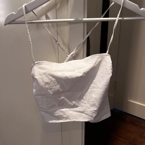 Vit croppad tubtopp från H&M Divided - Säljer en enkel och stilren vit croppad tubtopp från H&M Divided. Toppen har smala axelband och är perfekt för varma dagar eller som layering-plagg. Passar dig som gillar minimalistisk stil.
