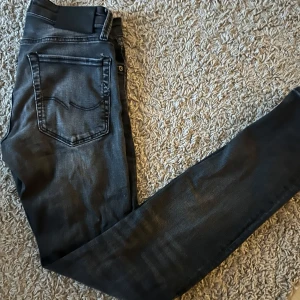 Jack & Jones Jeans slim fit - Säljer ett par svarta slim fit jeans från Jack & Jones, modell Glenn. Jeansen har klassisk femficksdesign, dragkedjegylf och smal passform. Perfekta för dig som gillar en stilren look med lite stretch.