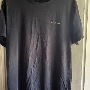 Svart t-shirt från Bondelid - Svart t-shirt från Bondelid med diskret broderad logga på bröstet. Klassisk rund halsringning och korta ärmar. Perfekt basic-plagg i mjuk bomull.