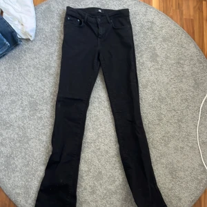 Svarta low waist jeans från LTB, modell Fallon - Svarta jeansbyxor från LTB i modellen Fallon. Byxorna har midwaist och flare passform, klassisk femficksdesign och stängs med dragkedja och knapp. Perfekta för dig som gillar en stilren look med lite utsvängda ben.