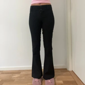 Kostymbyxor  - Snygga och klassiska svarta kostymbyxor från Gina Tricot i storlek S. Den har en figurnära passform upptill och lätt utsvängda ben nedtill. Byxorna har två knappar och dragkedja framtill samt hällor för skärp. Perfekta både till vardags och jobb/intervju.• Från djur- och rökfritt hem   Mått (plagget liggande platt):  Midja: ca 36 cm  Benlängd: ca 103 cm                                                📩 Skicka gärna ett meddelande vid frågor eller om du vill ha flera bilder! 🌸😊 