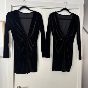Svart sammetsklänning med djup v-ringning - Säljer en svart sammetsklänning med lång ärm och djup v-ringning. Klänningen har en snygg twist-detalj framtill och är kort i modellen. Perfekt för dig som vill sticka ut på festen!
