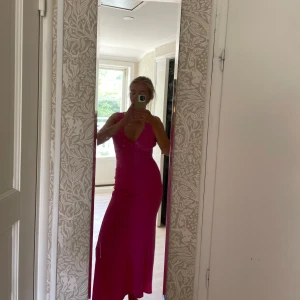 Rosa långklänning med djup rygg - Säljer en snygg rosa långklänning med v-ringning framtill och djup öppen rygg. Klänningen har en slits bak och är perfekt för bal, studentmottagning eller andra tillfällen. Materialet är mjukt och stretchigt! Bara använd 1 gång förra året.