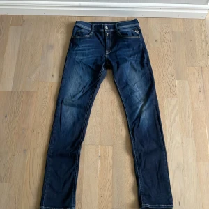 Replay Hyperflex jeans i blå denim - Säljer ett par Replay Hyperflex jeans i klassisk blå denim. Byxorna har fem fickor, dragkedja och knappar framtill samt snygga kontrastsömmar. Perfekta för dig som gillar stretchiga och bekväma jeans med modern passform. Hör av er vid frågor.