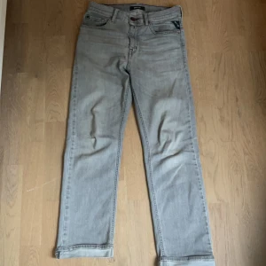 Gråa jeans från Replay - Snygga gråa jeans från Replay med klassisk femficksdesign och raka ben. Jeansen har normal passform och är tillverkade i ett mjukt denimtyg. Perfekta för dig som gillar stilrena och tidlösa byxor.