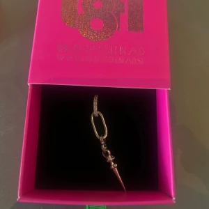 Silverfärgat örhänge l8Hasselblad - Coolt örhänge i silverfärg från l8Hasselblad, aldrig använd eller packat upp. Designen har en oval ring med en hängande spike-detalj som ger en edgy känsla. Perfekt för dig som vill sticka ut med dina accessoarer.