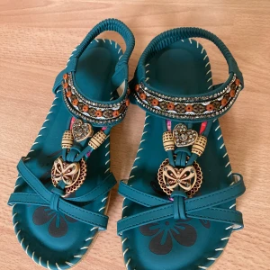Nya sandaler - Fina gröna sandaler med elastiskt band runt hälen Hela sulan är vadderad och även undersidan är mjuk Tyvärr lite för små (små i strl)