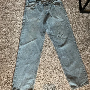 Ljusblå jeans från Swell Skateboarding - Från Junkyard. Ljusblå jeans från Swell Skateboarding Company med klassisk femficksdesign och raka ben. Jeansen har en snygg vintage-vibe och är tillverkade i robust denim. Perfekta för dig som gillar streetstyle och skatekänsla.