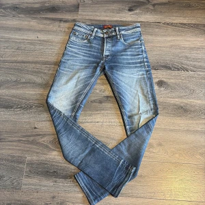 Slim fit jeans från Jack & Jones - Snygga blå slim fit jeans från Jack & Jones, modell Tim. Jeansen har klassisk femficksdesign, normal midja och lätt slitna detaljer för en cool look. Storlek 28/32 , pris går att diskutera. Hör av er vid frågor och funderingar. Jeansen är nästan aldrig använda