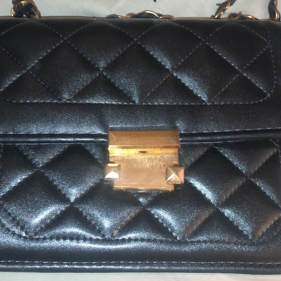 Svart quiltad axelväska med gulddetaljer - 1