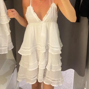 Klänning - Säljer en superfin vit volangklänning från Gina Tricot med tunna axelband och spetsdetaljer. Jag säljer den då jag ej har fått användning för den. Den är alltså i nyskick och endast testad. Den är i barnstorlek 170 men den sitter som en XS skulle jag säga. 🤗
