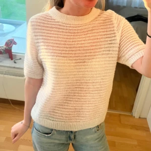 Vit stickad kortärmad mohair tröja - Säljer en vit stickad tröja med korta ärmar och rund hals, lite genomskinlig i mohair. Toppen skick!! 