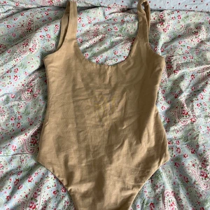 Beige body från Bik Bok - Säljer en enkel och stilren beige body från Bik Bok i storlek XS. Bodyn har breda axelband och rundad halsringning. Perfekt för casual men även utgång! 
