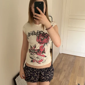 Ed Hardy t-shirt - Säljer en vit Ed Hardy t shirt med rosor på, original priset för tröjan var 700kr. Jag säljer den eftersom jag har slutat använda den, den är S men passar väldigt tight så skulle säga XS. Kontakta för mer frågor! 