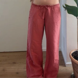  Roxy  linnebyxor  - Säljer ett par lösa och bekväma Roxy rosa linnebyxor med resår och dragsko i midjan. Byxorna har raka, vida ben och är perfekta för varma dagar. Supermjuka och luftiga!