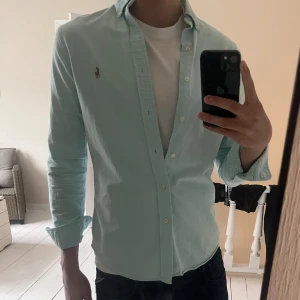 Ljusblå skjorta från Polo Ralph Lauren - Säljer en ljusblå skjorta från Polo Ralph Lauren i slim fit med klassisk button-down krage. Väldigt bra skick inga defekter.