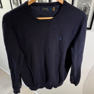 Polo Ralph Lauren tröja - Klassisk mörkblå stickad tröja från Polo Ralph Lauren. Nypris 2500kr mittpris 499kr. Skick as bra skriv vid funderingar!😊