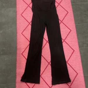 Svarta bootcut byxor Gina Tricot - Svarta bootcut byxor från Gina Tricot i stretchigt material. Hög midja och långa ben med utsvängda benslut. Perfekta för en trendig och bekväm look. Snygga att styla med crop top eller oversized hoodie.