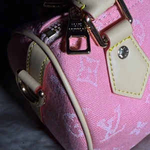 Rosa axelväska från Louis Vuitton i jeans - Säljer en rosa axelväska från Louis Vuitton i jeansmaterial med klassiskt monogrammönster. Väskan har beigea detaljer i skinn, guldfärgade metalldelar och dragkedja. Perfekt för dig som vill ha en snygg och trendig accessoar.