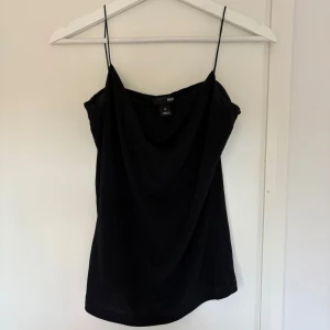 Svart linne / festtopp - Svart linnetopp från H&M med tunna axelband och draperad urringning. Tyget är lite glittrigt! 