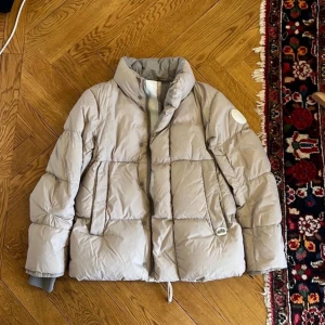 Beige dunjacka från Canada Goose - Canada Goose Everett puffer down jacket.              Storlek medium, ihopsydd på en armen, se på bilder.