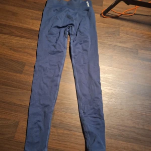 Blå leggings från DFYNE impact  - Säljer ett par blå leggings från DFYNE impact.  De är tillverkade i ett stretchigt material som passar perfekt för träning eller chill. Snygg logga på linningen och sömlös design för extra komfort.