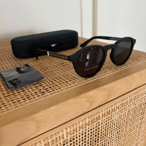 Helt nya solglasögon Tommy Hilfiger, nypris 1900 kr - Köpte dessa grymma Tommy Hilfiger som present till min son på flygplatsen i Malaga. Tyvärr var det inte rätt modell för honom, varför jag säljer dem. Nypris 1900 kr. Solglasögonen är helt nya. Modell TH 1476/S.