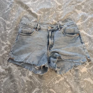 Ljusblå jeansshorts från LAB Industries - Snygga ljusblå jeansshorts från LAB Industries med råa, fransiga kanter och klassisk femficksdesign. Shortsen har normal passform och är perfekta för sommardagar. Tillverkade i 100% bomull för en skön känsla och avslappnad look💞