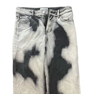 Gråsvarta wide jeans med bleach-effekt - 🌟Unika raka jeans från Pimki i svart med vita fläckar som ger ett coolt, edgy uttryck. Storlek 34. Fint skick och bekväma. Perfekta för dig som vill sticka ut med en personlig streetstyle-look. Knappt använda Använda få gånger. Skickas snabbt!📦