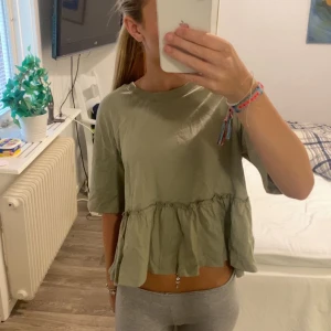 Grön volangtopp från Gina Tricot - Säljer en ljusgrön topp från Gina Tricot i storlek XS. Knappt använd och super fin! 