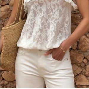 Vit spetslinne med volang från Nelly - Superfin vit blus från Nelly i transparent spets med tunna axelband och volangdetalj längs urringningen.Linnet har en luftig passform och är perfekt för varma dagar. Spetsmönstret ger en romantisk vibe och toppen är lätt att styla till jeans eller kjol. Ny med prislapp. Pris kan diskuteras vid snabb försäljning.