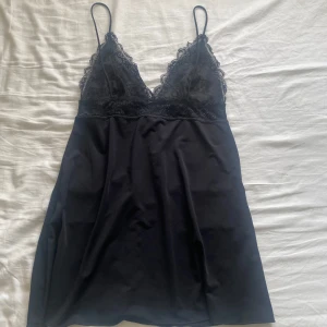 Svart nattlinne  - Supersnygg svart kortklänning med tunna axelband och v-ringning. 