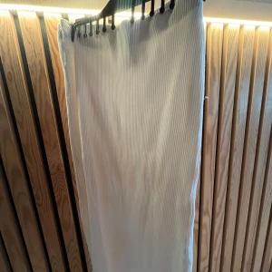 Vit ribbad långkjol från H&M - Säljer en vit långkjol från H&M i ribbat material. Kjolen har en rak och enkel passform med diskreta vertikala ränder som ger en snygg struktur. Perfekt för dig som gillar stilrena och minimalistiska plagg. Tvättas och strykes innan leverans såklart, tveka inte på att höra av er! 