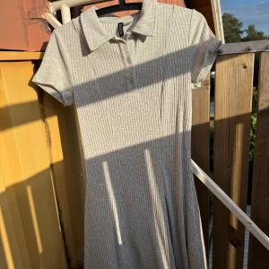 Ljusgrå ribbad kortklänning - Superfin ljusgrå ribbad kortklänning från H&M med klassisk krage och knappar framtill. Klänningen har korta ärmar och är figurnära upptill med lätt utställd kjol. 💞