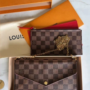 Louis Vuitton axelväska Damier Ebene - Nypris 14 400 kr. Louis Vuitton väska i modellen Pochette Félicie i Damier Ebene canvas. Allt medföljer i priset, dust bag, låda, korthållare samt plånbok med dragkedja. Kvittot och påsen finns också om man vill ha de.