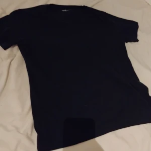 Svart v-ringad t-shirt Jean Pascale XL - En svart t-shirt från Jean Pascale i storlek XL. T-shirten har v-ringning och korta ärmar, perfekt basic-plagg till garderoben. Tillverkad i mjuk bomull för skön känsla och enkel stil.