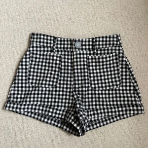 Svartvita rutiga shorts från Zara - Snygga svartvita rutiga shorts från Zara med hög midja och stora framfickor. Klassisk ginghamrutig design! Använda en gång, köparen står för frakten