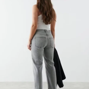 Gina tricot low waist straight jeans - Snygga grå jeans med raka ben och låg midja. Jeansen har klassiska bakfickor och en avslappnad passform som ger en cool vibe. Perfekta att matcha med en enkel topp eller hoodie.